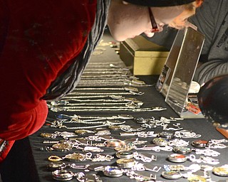 Katie Rickman | The Vindicator.Crystal Beiersdorfer of Youngstown looks at home crafted jewelry on sale  at the Artists of the Rustbelt "Last Minute Sale" at the B&O in Youngstown on Saturday, Dec. 20, 2014.