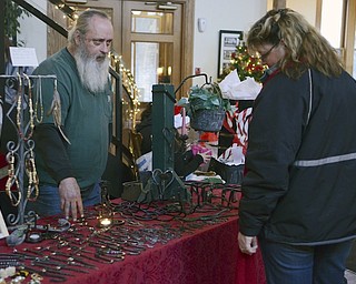 Katie Rickman | The Vindicator.Chris Jackson, on right of Austintown looks at home made crafts as artist Jeff Jones of Cortland points to a piece on the table at the Artists of the Rustbelt "Last Minute Sale" at the B&O in Youngstown on Saturday, Dec. 20, 2014.