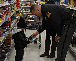 Deputy Tony Murphy (right) shows toys to Randy Triplett Jr. (2) of Youngstown during the Shop with a Cop event at Kmart in Boardman on Saturday morning.  Dustin Livesay  |  The Vindicator  12/20/14  Boardman