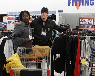 Anonio Riley (14,left) takes a break from shoppin for clothes to pose for a picture with Youngstown State University police officer JohnMcintyre during the Shop with a Cop event at Kmart in Boardman on Saturday morning.  Dustin Livesay  |  The Vindicator  12/20/14  Boardman