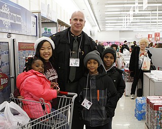 Sheriff Jerry Greene (middle) poses for a picture with (L-R) Kaycee King (4), volunteer Becca Choleva of the Boardman High School freshman cheerleading squad, Tylan Miller (9) and John Delgado (9) during the Shop with a Cop event at Kmart in Boardman on Saturday morning.  Dustin Livesay  |  The Vindicator  12/20/14  Boardman