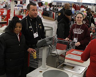 Prysund King (left,9) of Market Street School in Boardman goes through the checkout with Deputy Don Belosic (middle) and volunteer Alaina Fullerman, Boardman High School freshman cheerleader, during the Shop with a Cop event at Kmart in Boardman on Saturday morning.  Dustin Livesay  |  The Vindicator  12/20/14  Boardman