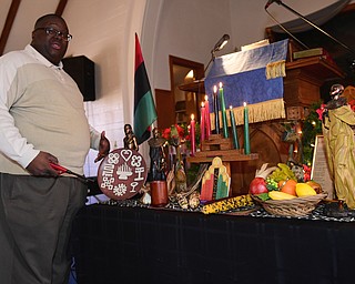 YOUNGSTOWN, OHIO - DECEMBER 22, 2014: Pastor Lewis Macklin lights the seven principles of Kwanza candles Monday afternoon at Holy Trinity Baptist Church. (Photo by David Dermer/Youngstown Vindicator)