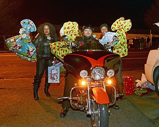 Katie Rickman | The Vindicator. LaDonna Harris, David Manigault and Mo "Sumnelse" Robinson hold up gifts outside of the Rescue Mission of Youngstown on Dec. 23, 2014., All three are apart of The Afro Dogs Motorcycle Club of Youngstown, the club donated aprox. $2, 000 worth of gifts to the children of the mission.