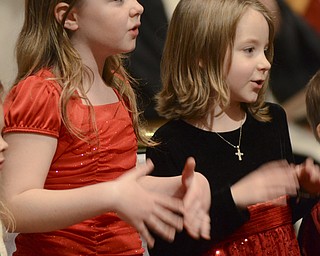 Katie Rickman | The Vindicator.Sisters Madison 9 and Sophia Edwards 6 of Canfield sing with the children's choir at  Canfield Presbyterian Church's Christmas Eve service on Dec. 24, 2014.