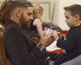 Katie Rickman | The Vindicator.Adam Holcomb holds his son 4-year-old son Tyler during the Christmas Eve service at Canfield Presbyterian on Dec. 24, 2014.