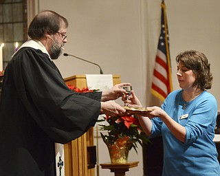 Katie Rickman | The Vindicator.Jyl Willloughby of Canfield receives communion from Rev. Larry Bowald and prepares to serve it to the congregation at Canfield Presbyterian during the Christmas Eve service at  on Dec. 24, 2014.