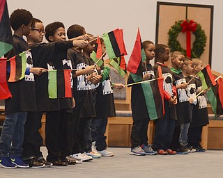 Katie Rickman | The Vindicator.Young men from the Harambee Youth Group of Youngstown hold up flags during the salute to the African-American flag portion of the celebration ceremony for the first night of Kwanzaa at New Bethel Baptist Church in Youngstown on Friday, Dec. 26, 2014.