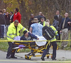 Katie Rickman | The Vindicator.A distraught parent is moved to a stretcher after daughter, Faith McCullough-Wooster, was killed after she was struck by a school bus on Wednesday, Nov. 12, 2014.