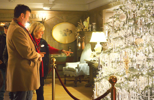 Robert Joshua, a former guide at the Arms Family Museum of Local History, and Tish Traficant relish the beauty of the twinkling Christmas tree adorned in crystals in the “Memories of Christmas Past” exhibit.