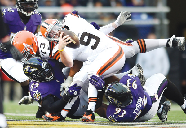 Browns rookie QB Connor Shaw is taken down by Ravens OL Terrell Suggs, bottom left, and DE DeAngelo
Tyson in the second half of their game Sunday at M&TBank Stadium in Baltimore. The Ravens rallied in the fourth
quarter to upend the Browns, 20-10, and earn a berth in the playoffs.