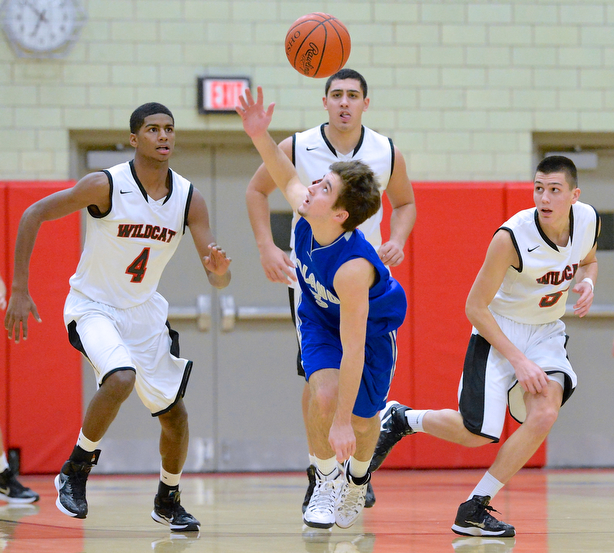 Jeff Lange | The Vindicator  Poland's Nick Gajdos (front center) eyes down the ball as he attempts to catch it as Wildcat players Ray Phifer (4), Austin Yemma (back center) and Andrew Carbon (right) trail the play from behind during first period action, Tuesday night in Struthers. The Poland Bulldogs downed the Wildcats 62-42.