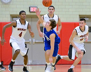 Jeff Lange | The Vindicator  Poland's Nick Gajdos (front center) eyes down the ball as he attempts to catch it as Wildcat players Ray Phifer (4), Austin Yemma (back center) and Andrew Carbon (right) trail the play from behind during first period action, Tuesday night in Struthers. The Poland Bulldogs downed the Wildcats 62-42.