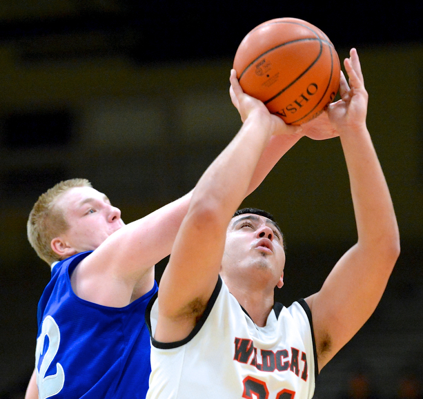Jeff Lange | The Vindicator  Wildcats' Austin Yemma (right) looks to make a two under Poland's Dan Black during first half action at Struthers High School, Tuesday night.