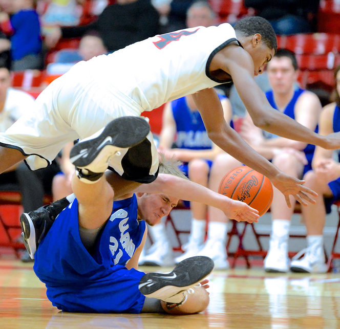 Jeff Lange | The Vindicator  Poland's Kyle Dixon (bottom) is trampled by Struthers' Ray Phifer (4) as they fight for possession of the ball during first half action at Struthers High School, Tuesday night. The Bulldogs beat the Wildcats 62-42.
