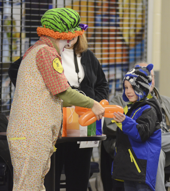 Katie Rickman | The Vindicator.Micah Sparks, 4 of Champion, smiles as Jot the Clown hands him a balloon animal at the Covelli Centre during First Night Youngstown.