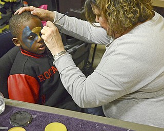 Katie Rickman | The Vindicator.Luke Queener, 5 of Atlanta, Georgia has his face painted as "wolverine" by Maria Jones of New Castle during the First Night Youngstown celebration at 20 Federal Place on Wednesday evening.