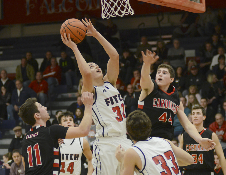 Katie Rickman | The Vindicator.Fitch's Dominic DiFrancesco (32) goes up for a shot at Canfield's (44) jumps up and attempts to block his shot during the first period at the game at Fitch High School on January 2, 2015.