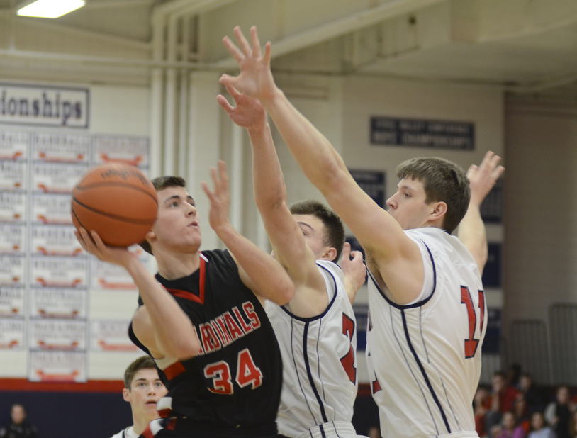 Canfield's Vince Leone (34) shoots and scores despite the attempted block by Austintown's Maalik Smith (2), center, and Anthony Pangio (11) during the first period at Fitch High School on January 2, 2015.