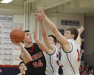 Canfield's Vince Leone (34) shoots and scores despite the attempted block by Austintown's Maalik Smith (2), center, and Anthony Pangio (11) during the first period at Fitch High School on January 2, 2015.