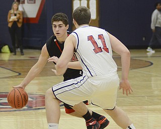 Katie Rickman | The Vindicator.Canfield's Mike Yourstowsky (14) moves down the court as Austintown's Anthony Pangio (11) attempts to block his path during the first period of the game at Austintown High School on Jan. 2, 2015.