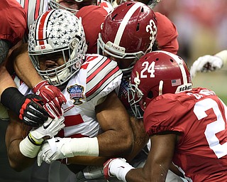 NEW ORLEANS, LOUISIANA - JANUARY 1, 2015: Ezekiel Elliott #15 of Ohio State is tackled by Trey DePriest #33 and Geno Smith #24 of Alabama during the 1st quarter of Thursday nights game at the Superdome. (Photo by David Dermer/Youngstown Vindicator)
