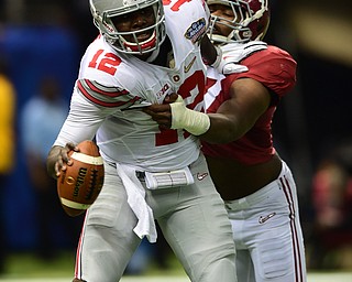 NEW ORLEANS, LOUISIANA - JANUARY 1, 2015: Cardle Jones #12 of Ohio State is sacked at the one hardline by Corey McCarron #47 of Alabama during the 1st quarter of Thursday nights game at the Superdome. (Photo by David Dermer/Youngstown Vindicator)
