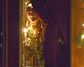 Katie Rickman | The Vindicator.Leah Wiodarski plays the part of a Sprite as she peeks through the glass door before skipping down the isle during the 54th annual Boar's Head & Yule Log Festival at St. John's Episcopal Church on Sunday, Jan. 4, 2014.