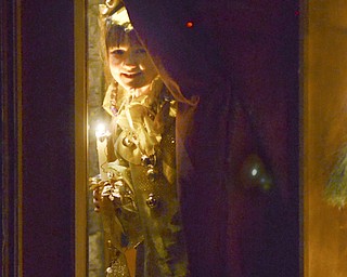 Katie Rickman | The Vindicator
Leah Wiodarski plays the part of a Sprite as she peeks through the glass door before skipping down the isle during the 54th annual Boar's Head & Yule Log Festival at St. John's Episcopal Church on Sunday, Jan. 4, 2014.