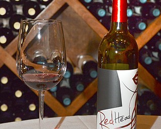 Katie Rickman | The Vindicator.A bottle of RedHead Wine developed by Cornell University senior Marisa Sergi next to a wine glass at Luva Bella Winery in Lowellville on Tuesday, Dec. 30, 2014.