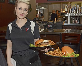 Katie Rickman | The Vindicator.Swan Bleacher of Youngstown serves burgers to the Burger Guyz during their visit to V2 downtown Youngstown on Tuesday, Dec. 30, 2014.