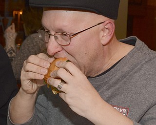Katie Rickman | The Vindicator.Burger Guyz's Anthony Fuda eats a burger during the groups visit to V2 downtown Youngstown on Dec. 30, 2014.