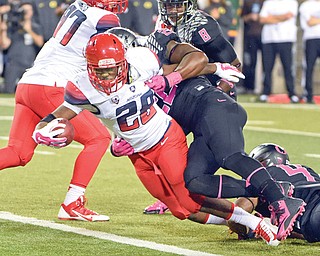 Arizona running back Nick Wilson (28) scores a touchdown as Oregon linebacker Derrick Malone tries to tackle him during the third quarter of a game in Eugene, Ore. Arizona won the game 31-24, handing Oregon its only defeat of the season.