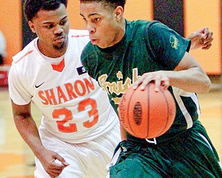 Ursuline’s David Collins (20) drives around Sharon’s Jaquan Waller (23) during Monday’s game in Sharon.