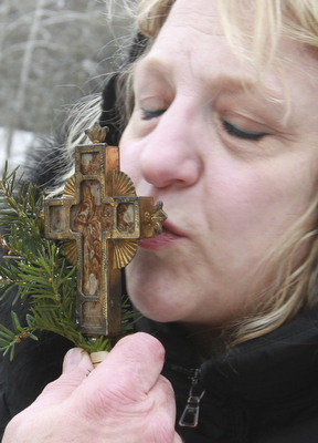 William D. Lewis The Vindicator Pattie Campos of Canfield kisses a crucifix during the annual Orthodox Blessing of the Water at Mill Creek Park  Tuesday 1-6-15.