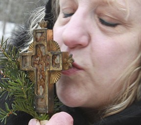 William D. Lewis The Vindicator Pattie Campos of Canfield kisses a crucifix during the annual Orthodox Blessing of the Water at Mill Creek Park Tuesday 1-6-15.