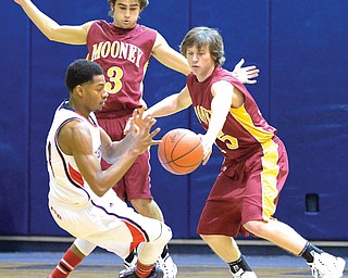 Cardinal Mooney’s Jonny Durkin (right) steals the ball away from Warren JFK’s A.J. Grant (left) as the Cardinals’ Nicholas Koken (3) helps out on defense in Tuesday’s game in Warren. Mooney shut down the Eagles’ offense on their way to a victory.