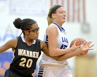 Jeff Lange | The Vindicator  Warren's Clarissa McKinney (20) reaches under the arm of Lakeview's Abby Pavlik (right) as she attempts to steal the ball away during first quarter action at Lakeview High School, Wednesday night.