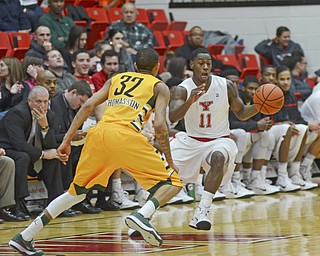 Katie Rickman | The Vindicator.Youngstown's DJ Cole (11) moves up court and is blocked by Wright State's Joe Thomasson (32) during the first period at YSU on Jan. 8, 2015.