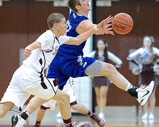 Jeff Lange | The Vindicator  Poland's Kyle Dixon (back) and Boardman's Gannon Murray collide as they both make a play for the ball during first half action at Boardman High School. Poland went on the beat the Spartans 58-37.