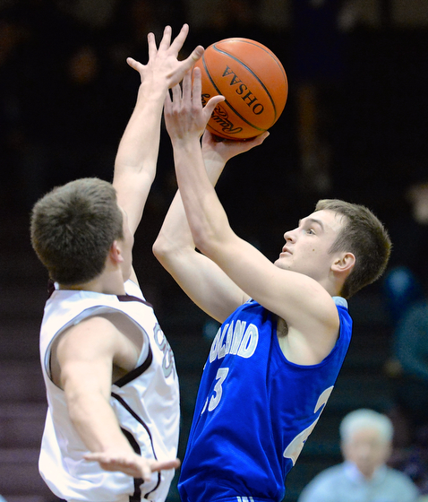 Jeff Lange | The Vindicator  Poland's Jared Burkert (right) looks over Boardman's Alex Duda (left) as he goes for a two point shot late in the fourth quarter of their matchup, Friday night in Boardman.