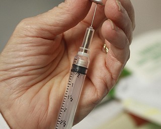        ROBERT K. YOSAY  | THE VINDICATOR..Flu vaccine as Brenda Christensen RN of Mahoning County Health Dept.. administers the flu vaccine at the Mahoning County Clinic in Austintown .