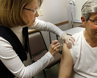        ROBERT K. YOSAY  | THE VINDICATOR..Flu vaccine as Brenda Christensen RN of Mahoning County Health Dept.. administers the flu vaccine at the Mahoning County Clinic in Austintown .