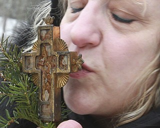 William D. Lewis The Vindicator Pattie Campos of Canfield kisses a crucifix during the annual Orthodox Blessing of the Water at Mill Creek Park Tuesday 1-6-15.