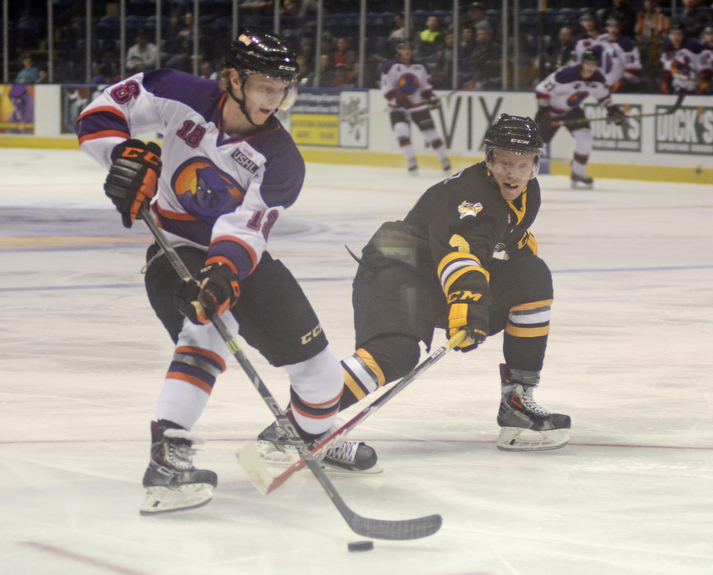 Katie Rickman | The Vindicator.Phantom's Kyle Conner (18) moves up the ice as Green Bay Gambler's (4) attempts to steal from him during the first period of the game at the Covelli Centre on Jan 10, 2015.