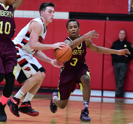 CANFIELD, OHIO - JANUARY 10, 2015: Kaylon Davis #3 of Liberty swipes the ball out of the hands of Mike Yourstowsky #14 of Canfield during the 2nd half of Saturday nights game at Canfield High School. (Photo by David Dermer/Youngstown Vindicator)