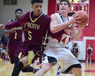 CANFIELD, OHIO - JANUARY 10, 2015: Mason Mangapora #44 of Canfield looks to the basket while Hyland Burton #5 of Liberty attempts to swat the ball out of his hands during the 2nd half of Saturday nights game at Canfield High School. (Photo by David Dermer/Youngstown Vindicator)