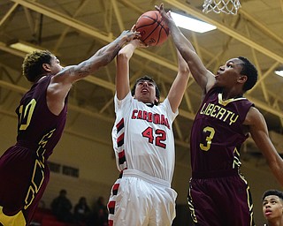 CANFIELD, OHIO - JANUARY 10, 2015: Sam Digiacomo #42 of Canfield muscles up a shot over Lynn Bowden #10 and Kaylon Davis #3 of Liberty during the 2nd half of Saturday nights game at Canfield High School. (Photo by David Dermer/Youngstown Vindicator)