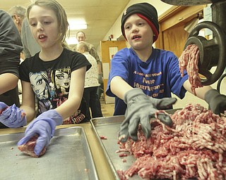William D Lewis the Vindicator Elizabeth McFarland, 8, and Heath Crouse, 6, help with sausage making at Mt Olivet Church in North Lima.