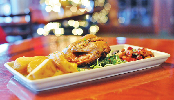Magic Tree Pub and Eatery’s Cornish game hen, deep fried and served with Chef Tank’s BBQ sauce, Blue Denim potato wedges and tri-color carrots and onions.
